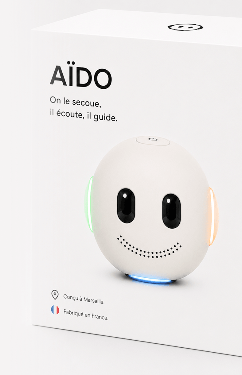 Le packaging d'AÏDO — boîte blanche, sphère et signature