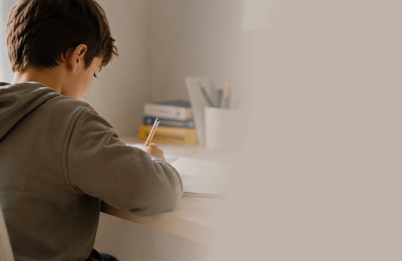 Un enfant qui fait ses devoirs à son bureau, la sphère AÏDO à côté